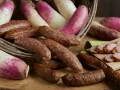 Salsicce e rape rosa in un cesto, pronte per la sagra della ciuiga. Un'esplosione di sapori autunnali.
