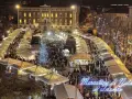 Un affollato Mercatino di Natale a Trento, con bancarelle illuminate, un albero scintillante e gente che passeggia tra le luci festive.