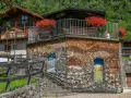 Un edificio unico in montagna, con pareti di legna e dipinti. Un vero spettacolo da vedere a Mezzano, tra natura e arte.