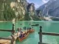 Gente in barca sul lago di Braies, dove si trova questo gioiello alpino. Montagne imponenti e acque turchesi.