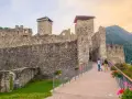 Castello di Stenico, uno dei tanti paesi da visitare vicino Dimaro, con una famiglia che passeggia sul ponte fiorito.