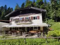 Rifugio alpino con tavoli all'aperto, ideale per rilassarsi dopo le ronzone passeggiate nel bosco.