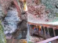 Persone percorrono una passerella metallica lungo le pareti rocciose di un canyon, vicino al Ponte dell'Orrido.