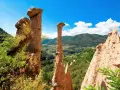Le Piramidi di Segonzano, un paesaggio unico da esplorare. Le formazioni rocciose scolpite dal tempo dominano la valle verdeggiante.