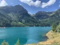 Il lago di Pian Palù, con le sue acque turchesi, è incastonato tra montagne ricoperte di fitti boschi di conifere.