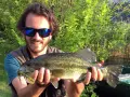 Felice pescatore con un grosso pesce appena pescato al lago di Levico.