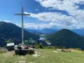 Croce in cima a una collina con vista panoramica su laghi e montagne, nei pressi di Bedollo, Trento.