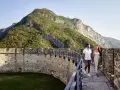 Coppia passeggia su un bastione di un castello con montagne verdi sullo sfondo. Un'esperienza da vivere nel Trentino da scoprire.