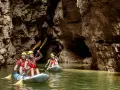 Kayakisti esplorano il suggestivo lago di Santa Giustina canyon, tra pareti rocciose imponenti e acque verdi.
