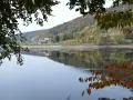 Autunno a Baselga di Pinè: il lago riflette le case e i boschi colorati. Cosa vedere in questo incantevole borgo trentino.