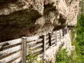 Sentiero panoramico con staccionata in legno lungo la roccia, vicino a Sanzeno San Romedio.