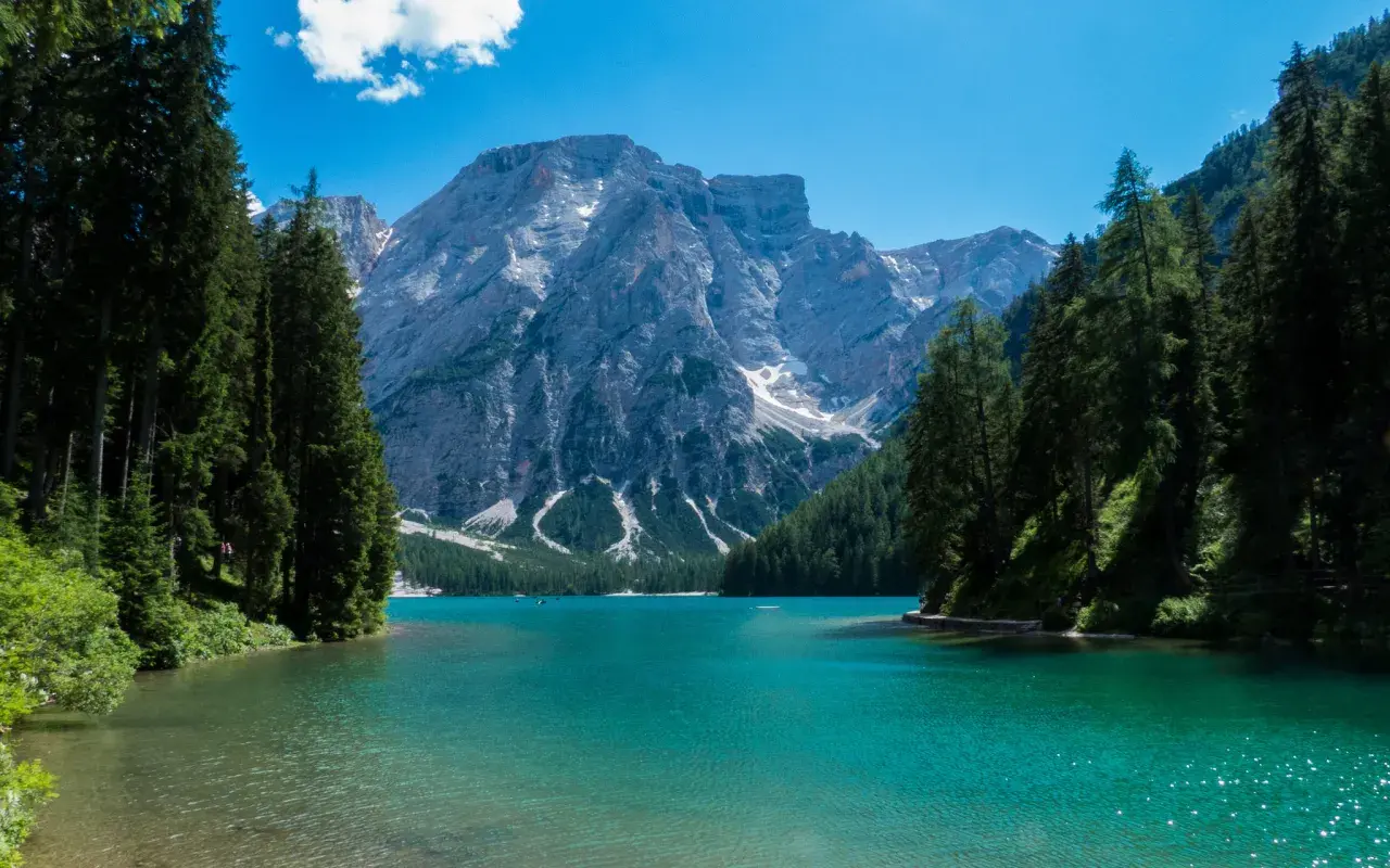 Lago di Braies, perla del tour Trentino, con montagne imponenti e acque cristalline.