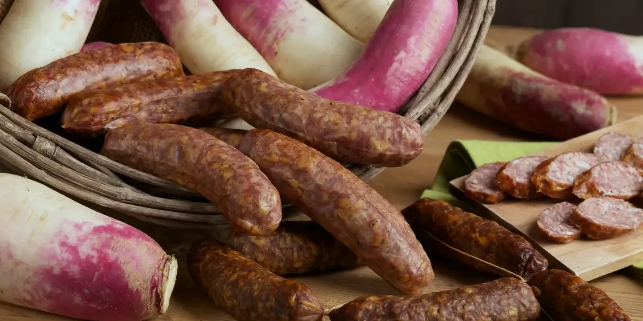 Salsicce e rape rosa in un cesto, pronte per la sagra della ciuiga. Un'esplosione di sapori autunnali.