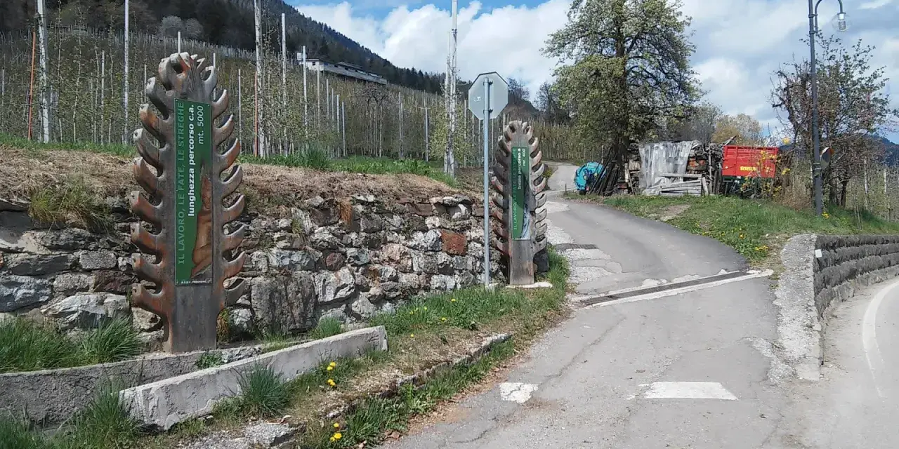 Inizio del sentiero delle fate, con cartelli informativi e un paesaggio montano.