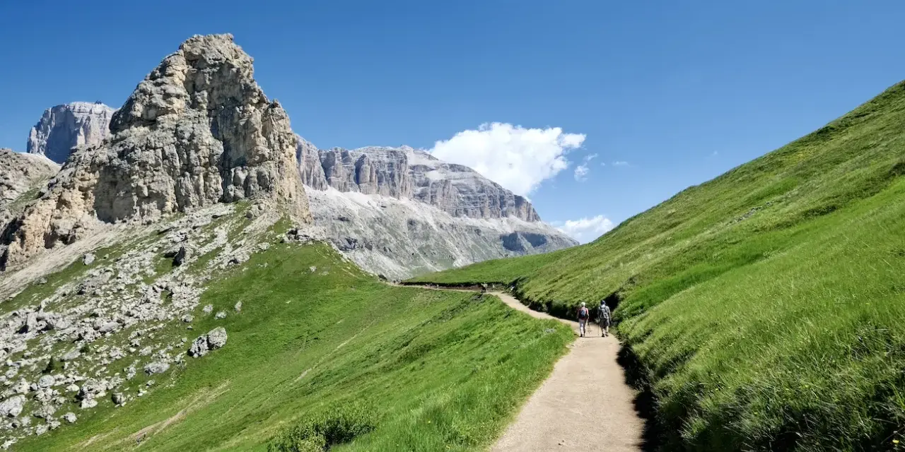 Sentiero nel verde del Val di Fassa, tra le vette maestose. Un'esperienza indimenticabile per le escursioni più belle.