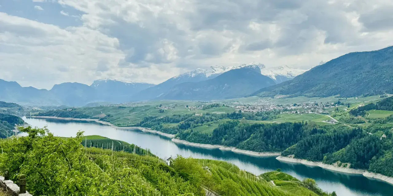Panorami mozzafiato sul lago di Santa Giustina, ideali per passeggiate tra frutteti e montagne innevate.