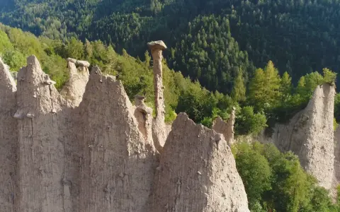 Le piramidi di terra del Val di Cembra, un paesaggio unico da scoprire, con rocce scolpite dal tempo e vegetazione rigogliosa.