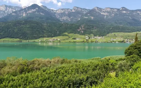 Lago di Caldaro, un gioiello verde smeraldo incastonato tra vigneti e montagne. Cosa vedere a Ronzone? Questo paesaggio mozzafiato è solo un assaggio.