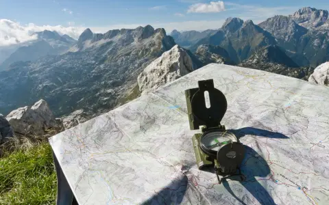 Bussola e mappa del passo della Fricca, con un panorama mozzafiato sulle montagne.