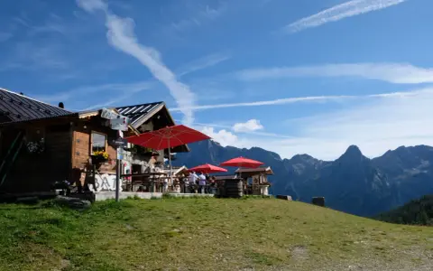 Rifugio alpino con tavoli all'aperto e vista sulle montagne, ideale per il giro delle malghe San Martino di Castrozza.