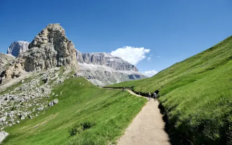 Sentiero nel verde del Val di Fassa, tra le vette maestose. Un'esperienza indimenticabile per le escursioni più belle.