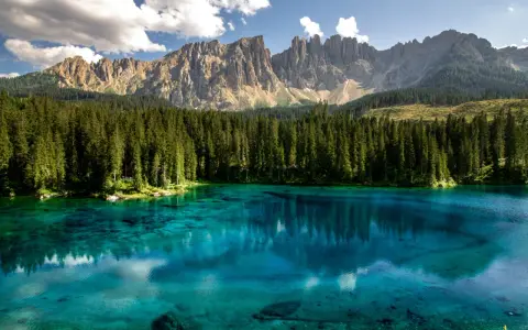 Lago di Carezza, un gioiello tra i boschi e le Dolomiti del Trentino, dove andare per un'immersione nella natura.