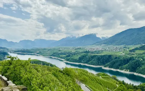 Panorami mozzafiato sul lago di Santa Giustina, ideali per passeggiate tra frutteti e montagne innevate.