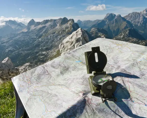 Bussola e mappa del passo della Fricca, con un panorama mozzafiato sulle montagne.