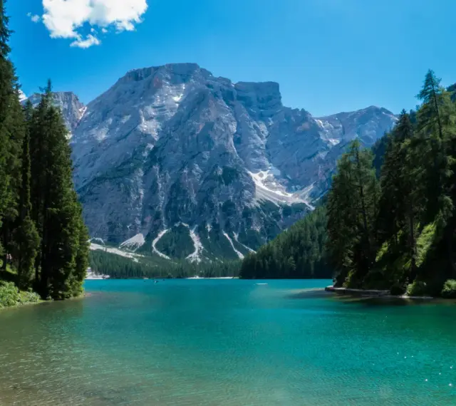 Lago di Braies, perla del tour Trentino, con montagne imponenti e acque cristalline.