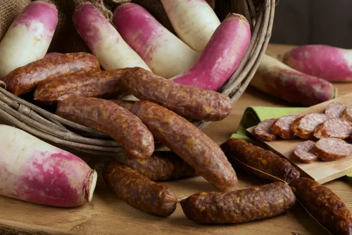Salsicce e rape rosa in un cesto, pronte per la sagra della ciuiga. Un'esplosione di sapori autunnali.