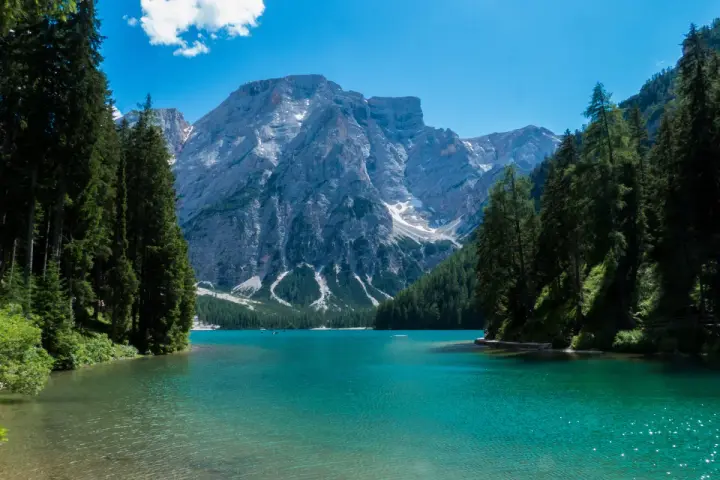 Lago di Braies, perla del tour Trentino, con montagne imponenti e acque cristalline.