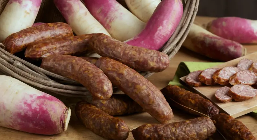 Salsicce e rape rosa in un cesto, pronte per la sagra della ciuiga. Un'esplosione di sapori autunnali.