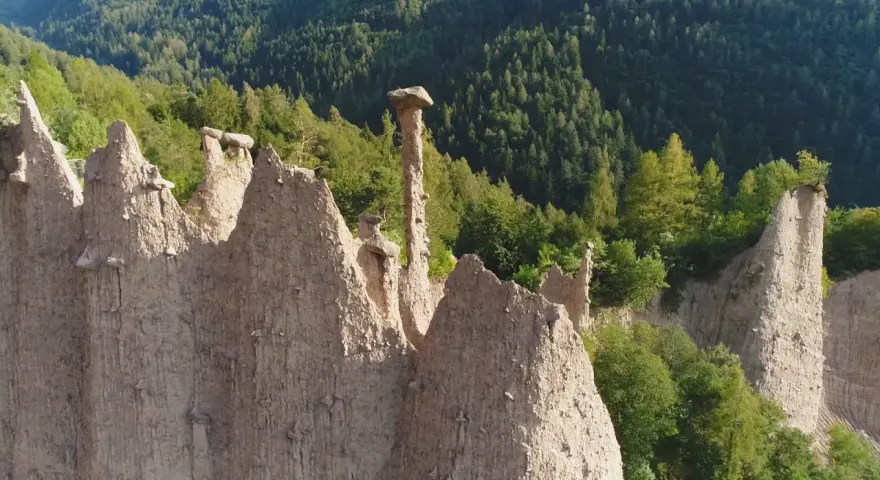 Le piramidi di terra del Val di Cembra, un paesaggio unico da scoprire, con rocce scolpite dal tempo e vegetazione rigogliosa.