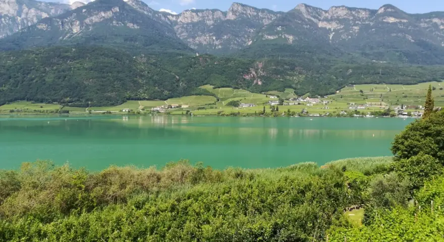 Lago di Caldaro, un gioiello verde smeraldo incastonato tra vigneti e montagne. Cosa vedere a Ronzone? Questo paesaggio mozzafiato è solo un assaggio.