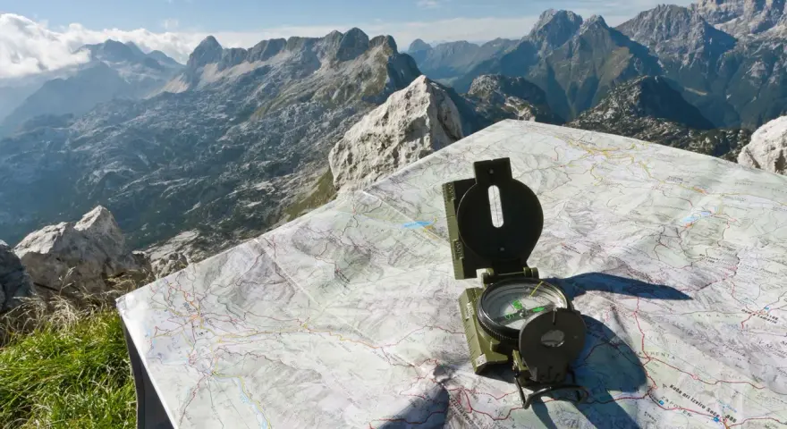 Bussola e mappa del passo della Fricca, con un panorama mozzafiato sulle montagne.