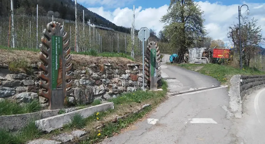 Inizio del sentiero delle fate, con cartelli informativi e un paesaggio montano.