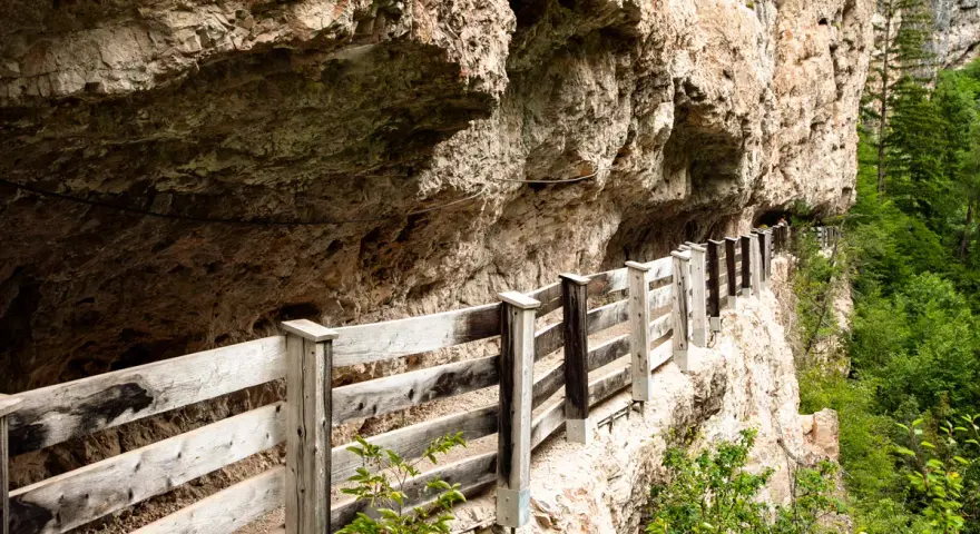 Sentiero panoramico con staccionata in legno lungo la roccia, vicino a Sanzeno San Romedio.