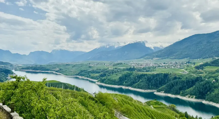 Panorami mozzafiato sul lago di Santa Giustina, ideali per passeggiate tra frutteti e montagne innevate.