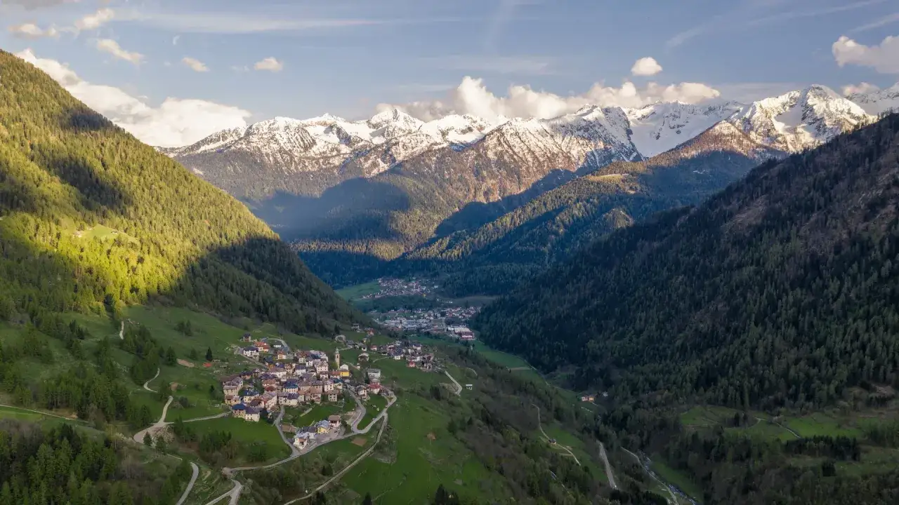 Villaggio di Folgarida, dove si trova, incastonato tra verdi pendii boscosi e maestose cime innevate.