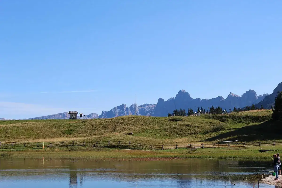 Lago alpino con montagne sullo sfondo. Per capire passo Lavazè come arrivare, immagina questo panorama sereno.