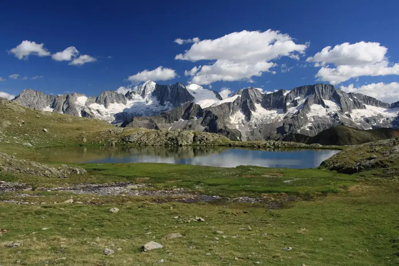 Laghi Val di Sole raggiungibili in auto, con montagne innevate sullo sfondo e cielo azzurro.