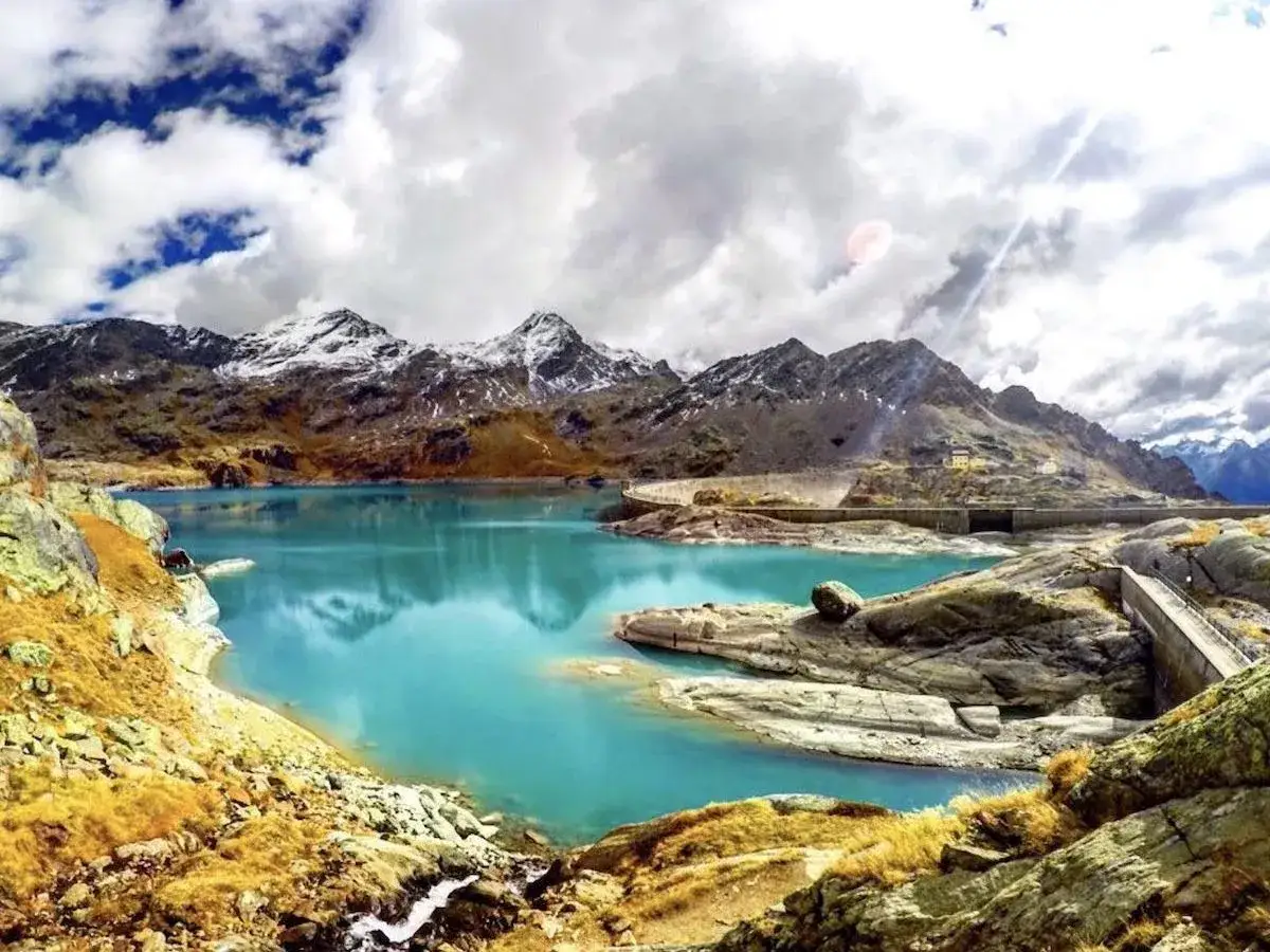 Il lago di Barco, con le sue acque turchesi, &egrave; incastonato tra montagne innevate e rocce dorate. Una diga imponente controlla il suo bacino.