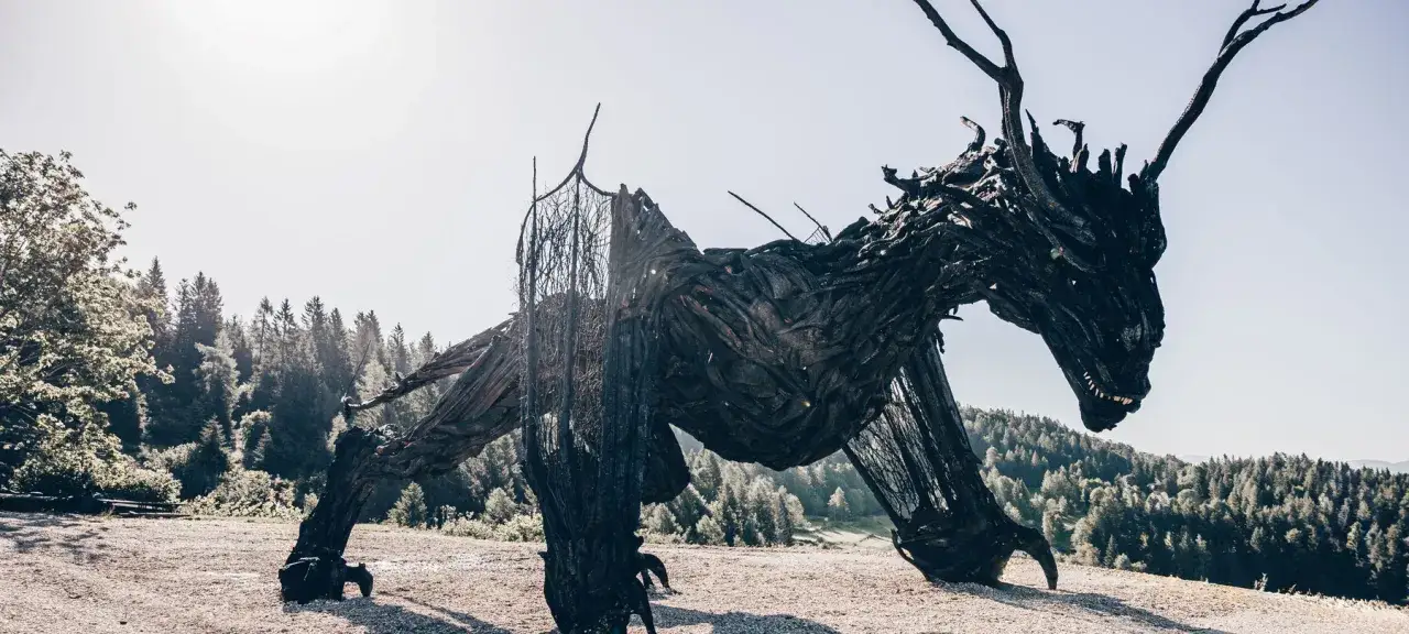 Il drago di Vaia, scultura imponente fatta di legno, si erge maestoso tra i boschi.