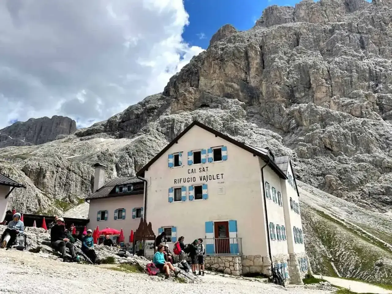 Escursioni alle volpi del Vajolet: un rifugio accogliente ai piedi delle maestose Dolomiti, dove gli escursionisti si riposano.