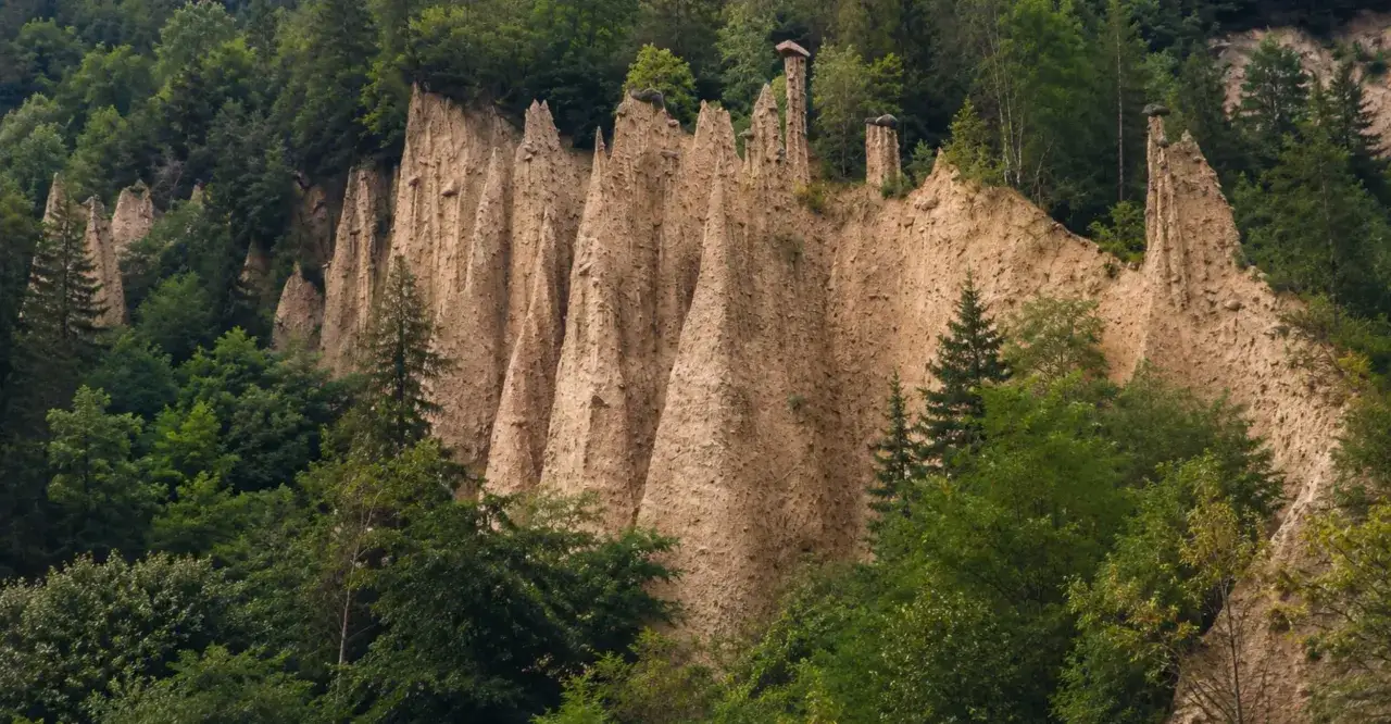 Le piramidi di terra di Segonzano, un paesaggio unico da vedere, si ergono maestose tra la vegetazione lussureggiante.