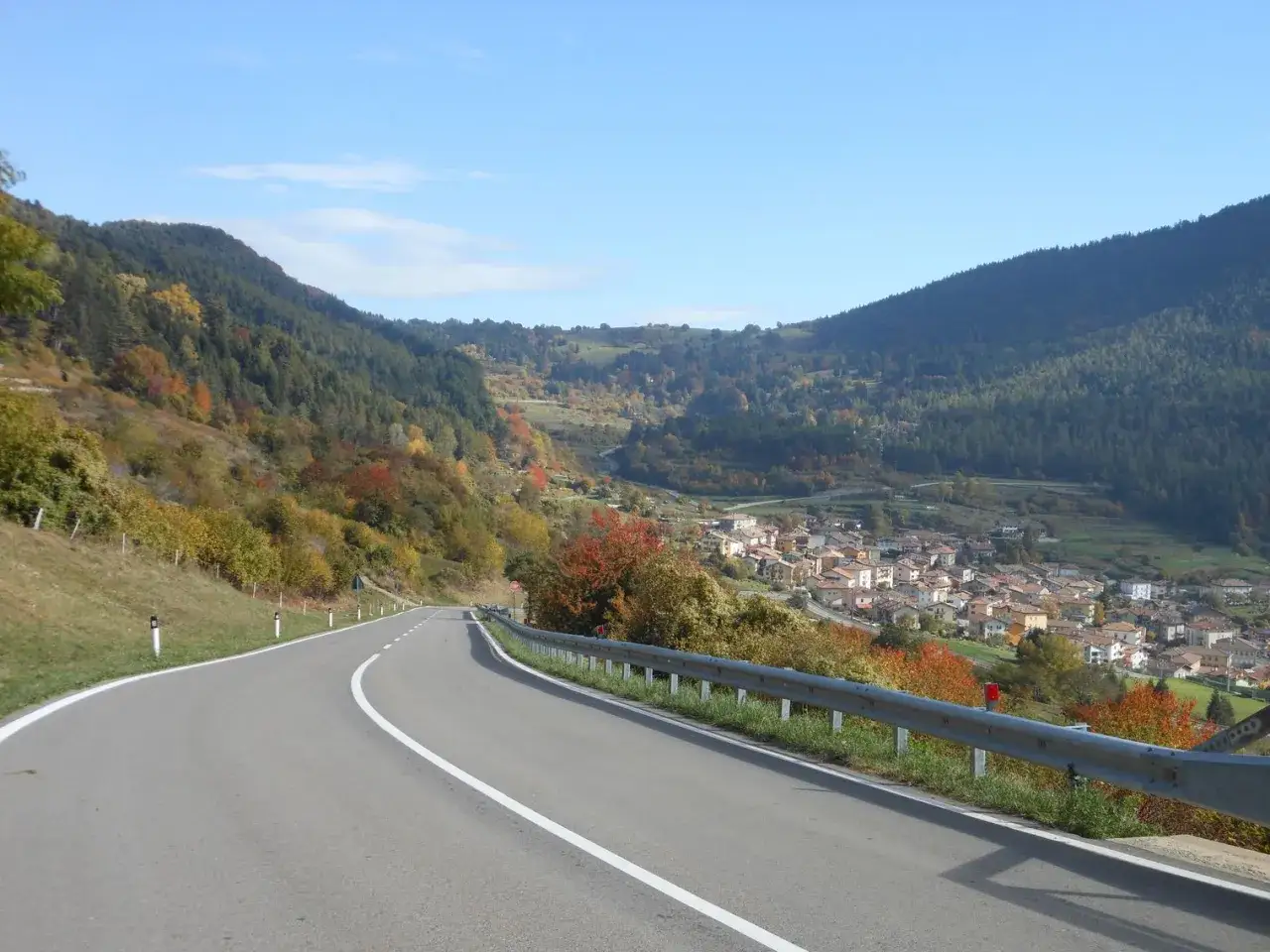 Strada panoramica in autunno verso un paese nel Passo di Santa Barbara, Trento.