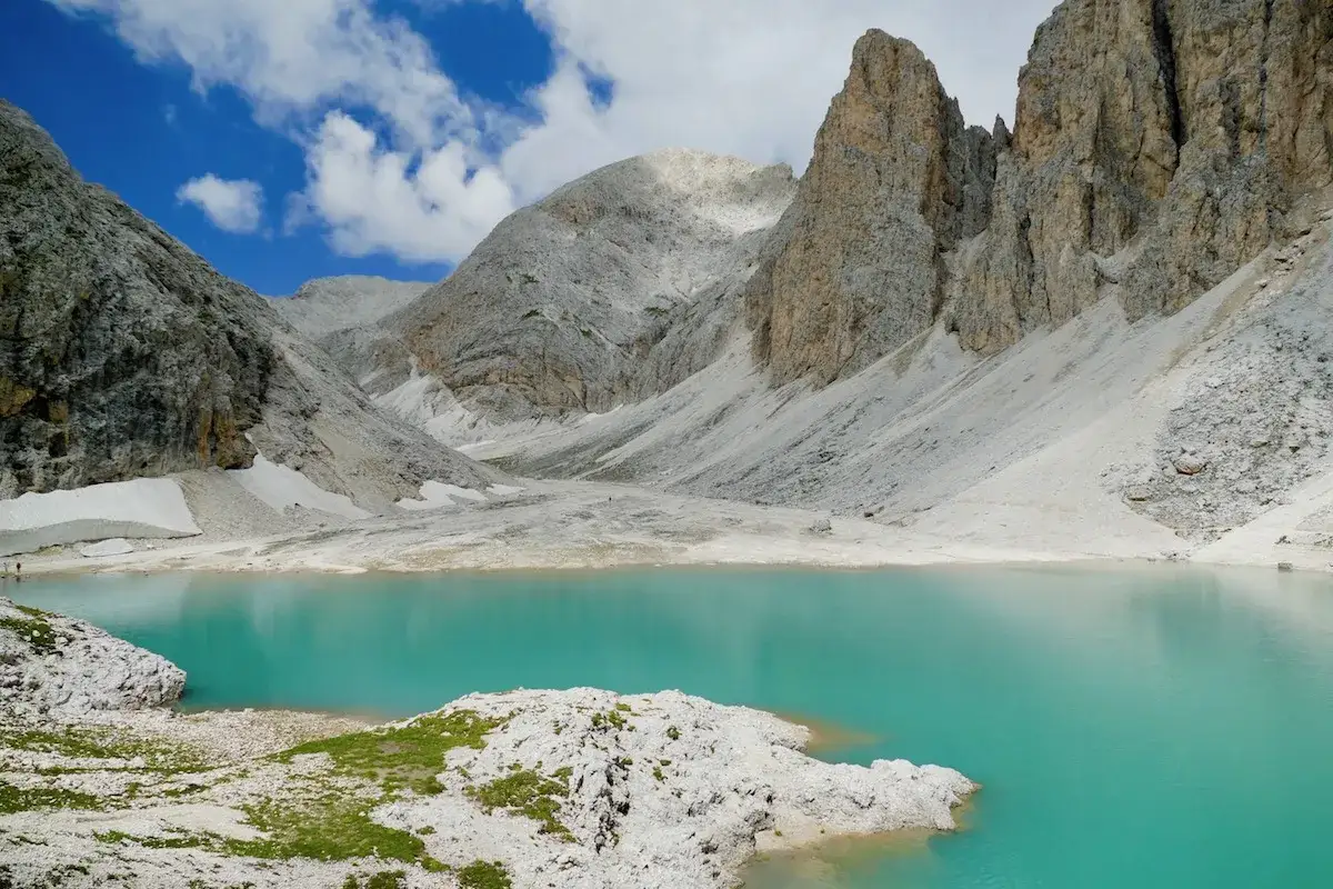Lago turchese ai piedi di maestose vette rocciose, ideale per indimenticabili antermoia passeggiate.