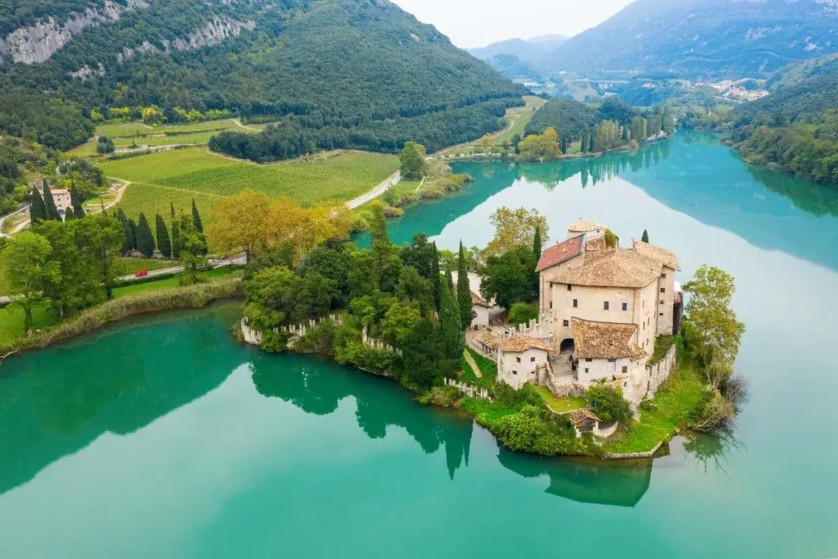 Castello sul lago di Toblino, circondato da vigneti e montagne. Scopri come arrivare per ammirare questo incanto.