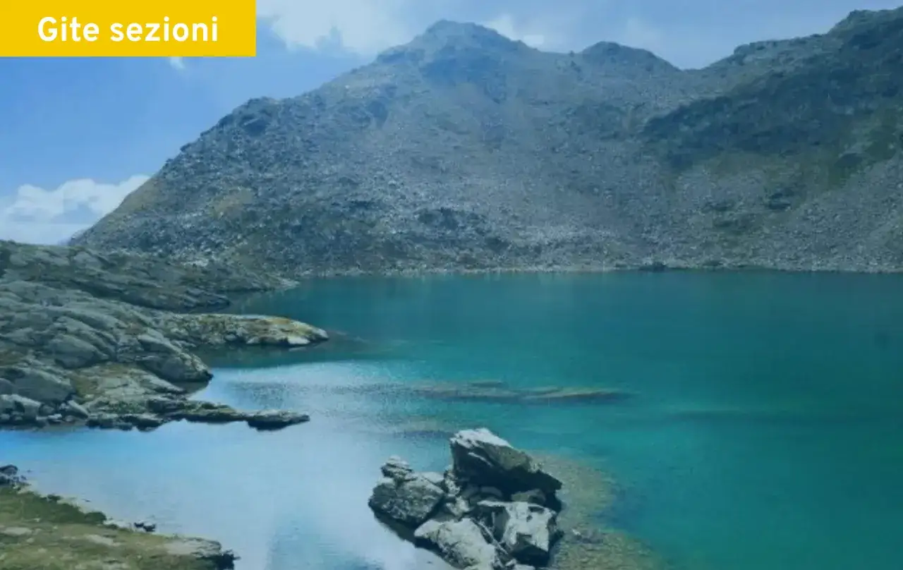 Splendido lago corvo alpino con acque turchesi e montagne rocciose sullo sfondo.