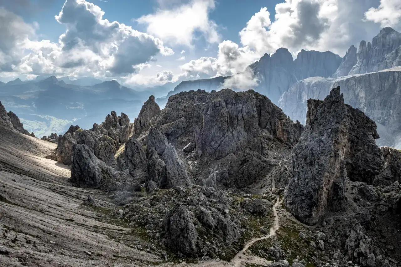 Sentiero tortuoso tra rocce aspre, con vette imponenti che si stagliano all'orizzonte. La passo gardena altitudine offre panorami mozzafiato.